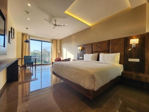 a bedroom with a large bed and a living room at Portola Hotel By Parkside in Dharamshala