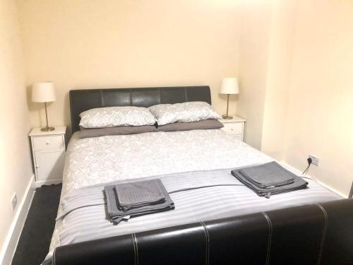 a bedroom with a large bed with two night stands at AC Lounge 115 in Rochford