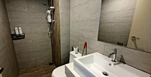 ein Badezimmer mit einem Waschbecken, einem Spiegel und einem WC in der Unterkunft ARTE+ @ JALAN AMPANG by ST Nomad in Kuala Lumpur