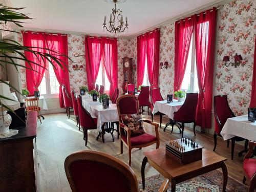 un restaurant avec des rideaux rouges, des tables et des chaises dans l'établissement Hotel de Charme La Bonne Adresse, au Havre