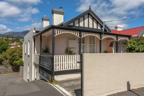 a house with a white fence in front of it at Kallara House walk to restaurant strip in New Town
