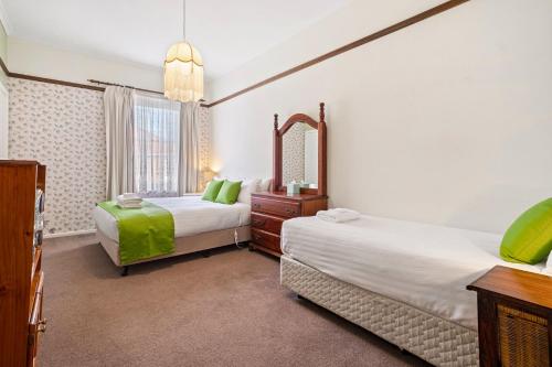 a bedroom with two beds and a mirror at Kallara House walk to restaurant strip in New Town