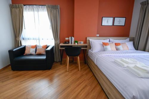 a bedroom with a bed and a chair and a desk at You Hotel in Ban Zong Katiam