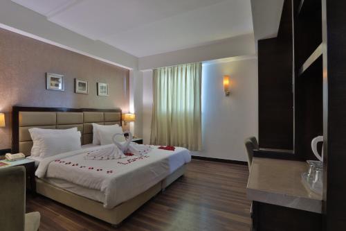 a hotel room with a large bed in a room at Krios Hotel in Ahmedabad