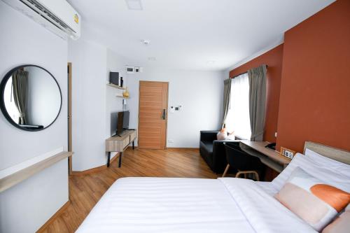 a bedroom with a bed and a desk and a mirror at You Hotel in Ban Zong Katiam