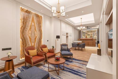 Ajman Hotel by Blazon Hotels في عجمان: غرفة معيشة مع كراسي وطاولة