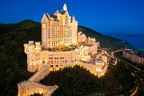 un gran edificio en la cima de una montaña por la noche en The Castle Hotel, a Luxury Collection Hotel, Dalian, en Dalian