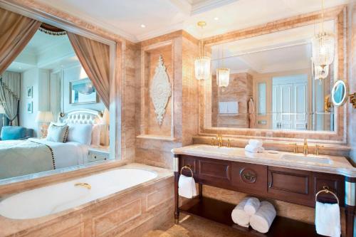a bathroom with a large tub and a bed at The Castle Hotel, a Luxury Collection Hotel, Dalian in Dalian