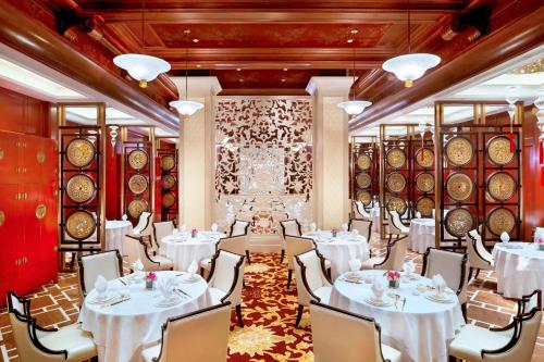 a banquet room with white tables and chairs and wine barrels at The Castle Hotel, a Luxury Collection Hotel, Dalian in Dalian