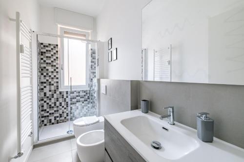 Baño blanco con aseo y lavamanos en Casa di Lolli, en Milán