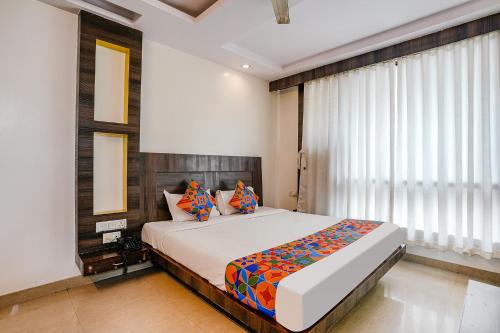 a bedroom with a large bed and a window at FabHotel Kingdom Sai in Shirdi