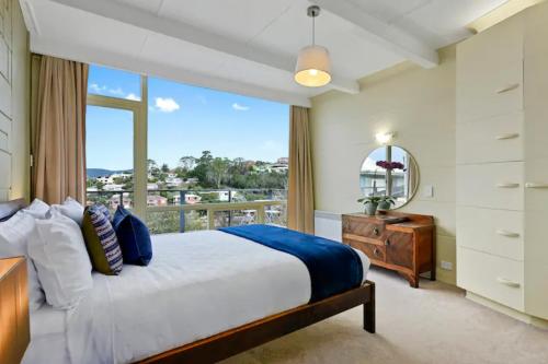 ein Schlafzimmer mit einem großen Bett und einem Fenster in der Unterkunft Poet s House 6br fabulous character WOW views in Hobart