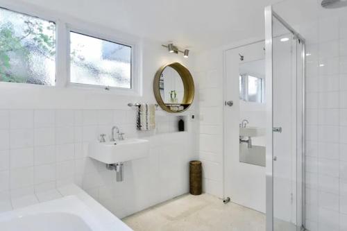 a white bathroom with a sink and a mirror at Poet s House 6br fabulous character WOW views in Hobart