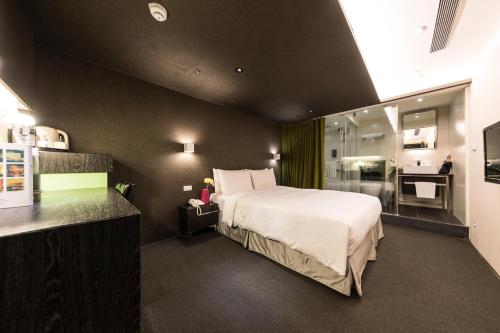1 dormitorio con 1 cama grande y baño en 凡登台北商務旅店 en Taipéi