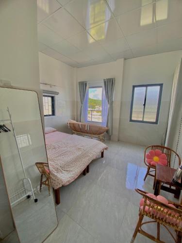 a large room with two beds and a mirror at Homestay Tuyết Trinh in Nha Trang