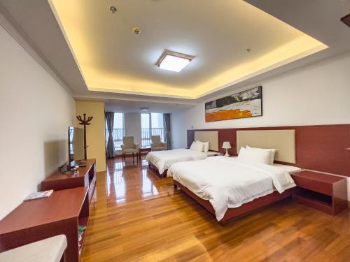 a hotel room with two beds and a television at Guangzhou Zhicheng Leader Tour International Apartment in Guangzhou