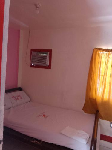 ein kleines Schlafzimmer mit einem Bett und einem Fenster in der Unterkunft WJV INN Cordova in Cebu City