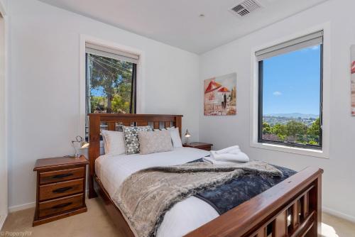 een slaapkamer met een groot bed en 2 ramen bij The Artview fantastic city location os parking in Hobart