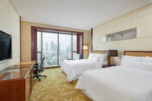 天津的住宿－天津君隆威斯汀酒店，酒店客房设有两张床和一台平面电视。