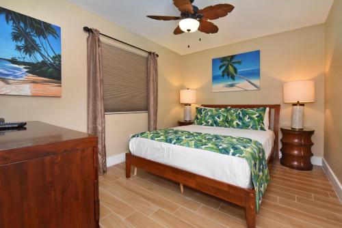 een slaapkamer met een bed en een plafondventilator bij Pacific Shores B102 in Kihei