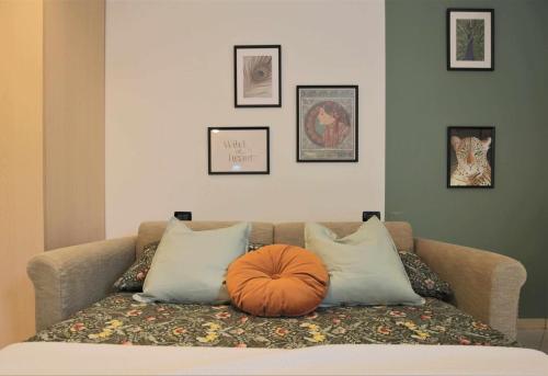 un sofá marrón con almohadas y una calabaza en él en Il Verde nel Corso en Cento