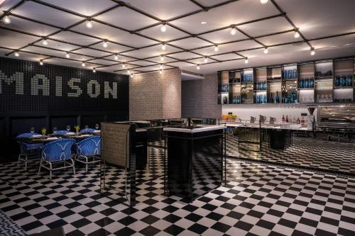a restaurant with a bar with a checkered floor at Renaissance Nanning Hotel in Nanning