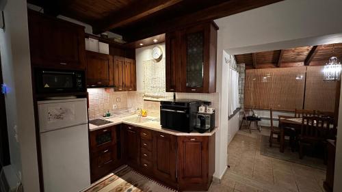 uma cozinha com armários de madeira e uma sala de jantar em Tripio Lithari - Arachova Vacation Home em Arachova