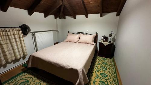 um pequeno quarto com uma cama com almofadas cor-de-rosa em Tripio Lithari - Arachova Vacation Home em Arachova