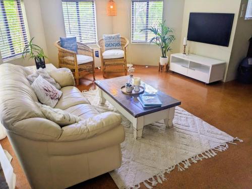 uma sala de estar com um sofá e uma mesa de centro em Bright & breezy chalet close to town & beach em Dunsborough