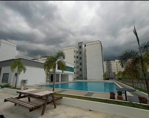 a swimming pool with a picnic table and a building at Ana Summer Homestay in Ipoh