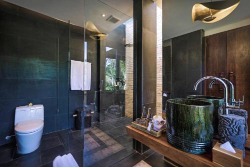 a bathroom with a shower and a sink and a toilet at Sanna Ubud A Pramana Experience in Tegalalang
