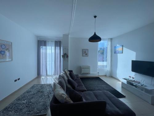 een woonkamer met een bank en een tv bij Dardana&Gerjon apartament in Bathoria