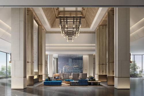 a lobby with blue furniture and a chandelier at Courtyard by Marriott Liuzhou Sanjiang in Sanjiang