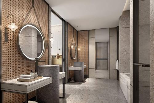 a bathroom with two sinks and a mirror at Courtyard by Marriott Liuzhou Sanjiang in Sanjiang