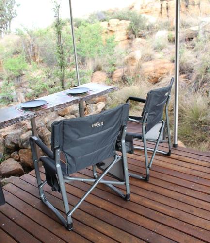 two chairs and a picnic table on a deck at Luxury Treehouse on Bronberg Ridge in Tierpoort