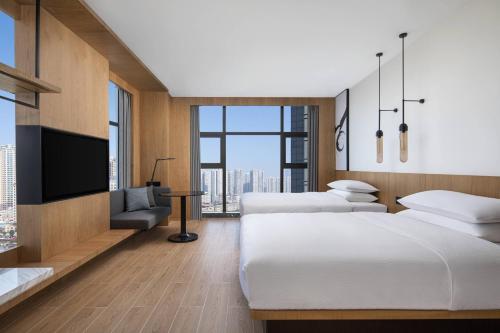 貴陽市にあるFairfield by Marriott Guiyang Guanshanhuのベッド2台、薄型テレビが備わるホテルルームです。
