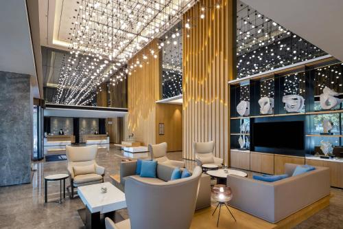a lobby with couches and chairs and a television at Fairfield by Marriott Guiyang Guanshanhu in Guiyang