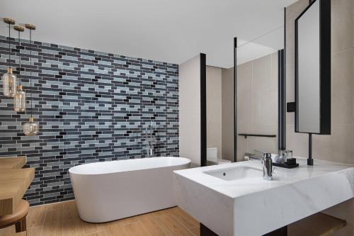 a bathroom with a white sink and a tub at Fairfield by Marriott Guiyang Guanshanhu in Guiyang