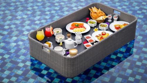 a table with food and drinks in a wicker table at Lembongan Beach Club & Resort in Nusa Lembongan