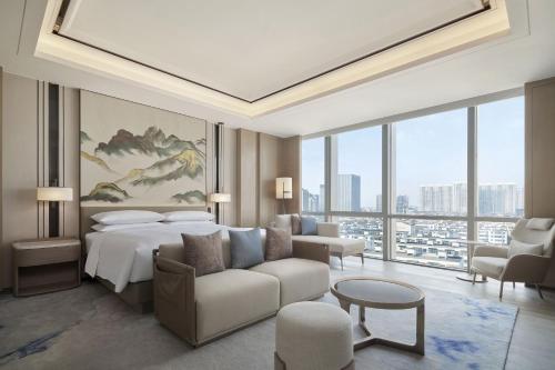 a hotel room with a bed and a couch at Four Points by Sheraton Suzhou, Wuzhong in Suzhou