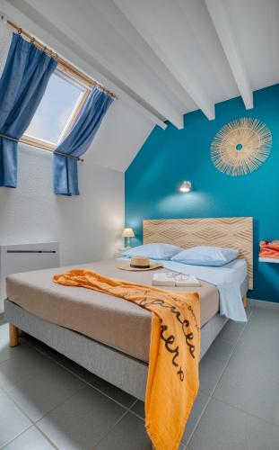 - une chambre avec 2 lits aux murs bleus et une fenêtre dans l'établissement KER-AR-MOR Village Vacances, à Clohars-Carnoët