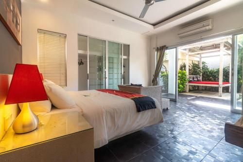 a bedroom with a bed and a table with a lamp at Aleesha Villas and Suites in Sanur