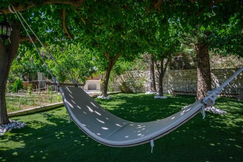 a hammock hanging from a tree in a yard at Kipo Paradiso Spa, Yoga & Gym Resort in Kiriánna