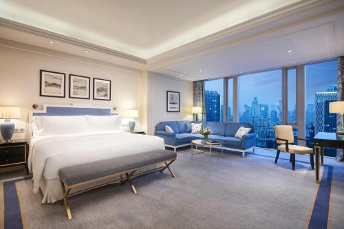 um quarto com uma cama grande e uma janela grande em The Azure Qiantang, a Luxury Collection Hotel, Hangzhou em Hangzhou