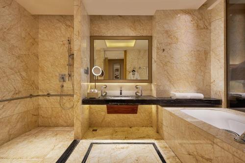 a bathroom with a tub and a sink and a mirror at The Westin Fuzhou Minjiang in Fuzhou