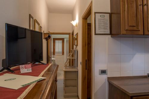 una cocina con mesa y TV. en Hotel La Fonte Del Cerro en Saturnia