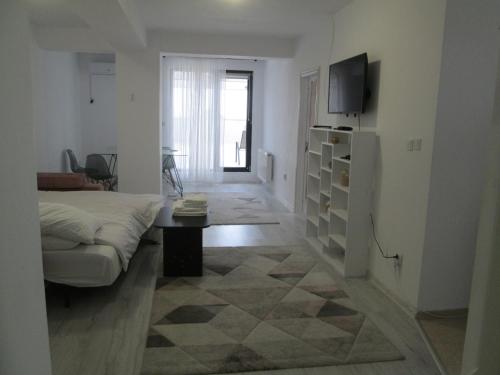 a white living room with a couch and a tv at Happy Residence in Craiova