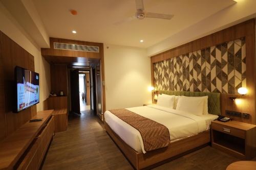 a bedroom with a bed and a flat screen tv at MANDARIN SKY in Kannur