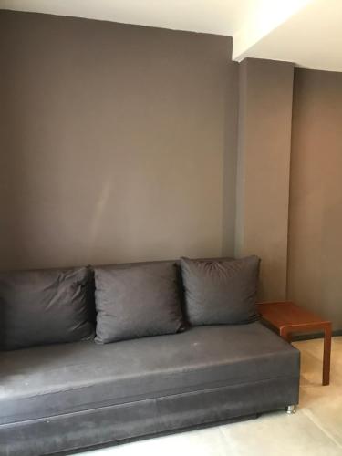Un sofá gris en una habitación con una pared. en Baņuta_2, en Saulkrasti