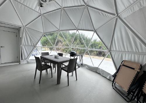 a room with a table and chairs in a tent at glampark resort Akuna beach in Henza